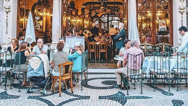 Un edificio decorato con un caffè al piano terra, chiamato 'Majestic Cafe'.