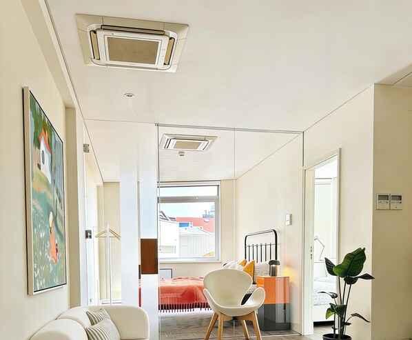 Een modern interieur met een bank, een stoel, een bed en een potplant.