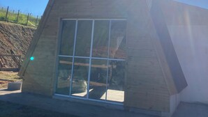 A modern, triangular-shaped building with large windows and a sloped roof. - Paraitinga Glamping  (São Luiz do Paraitinga)