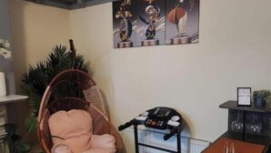 Ein Zimmer mit Stehtisch, Stuhl, Laufband und Heizkörper.