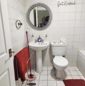 A bathroom with a white sink, toilet, and a mirror with a decorative frame. - Headline:
Charming Ground-Floor Retreat with Private Garden in Wolverhampton (Wolverhampton)