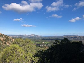 Un paysage montagneux, avec un ciel dégagé et quelques nuages épars.