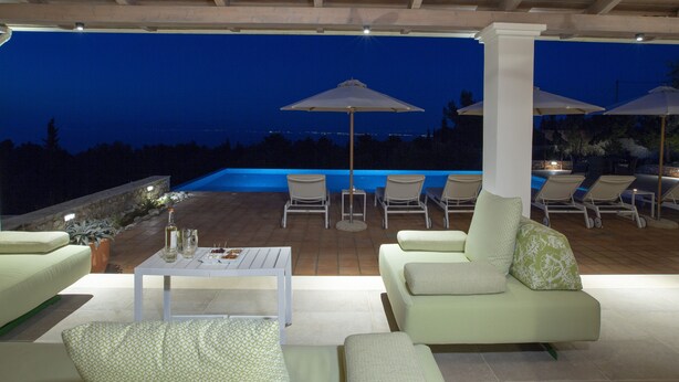 An outdoor patio with a pool, lounge chairs, and a table with drinks. - Villa Borsa: Secluded Retreat with Sea Views, Gym and near famous beaches (Lefkada)