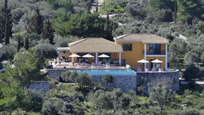 A two-story villa with a swimming pool, outdoor seating, and a stone wall surrounding the pool area. - Villa Borsa: Secluded Retreat with Sea Views, Gym and near famous beaches (Lefkada)