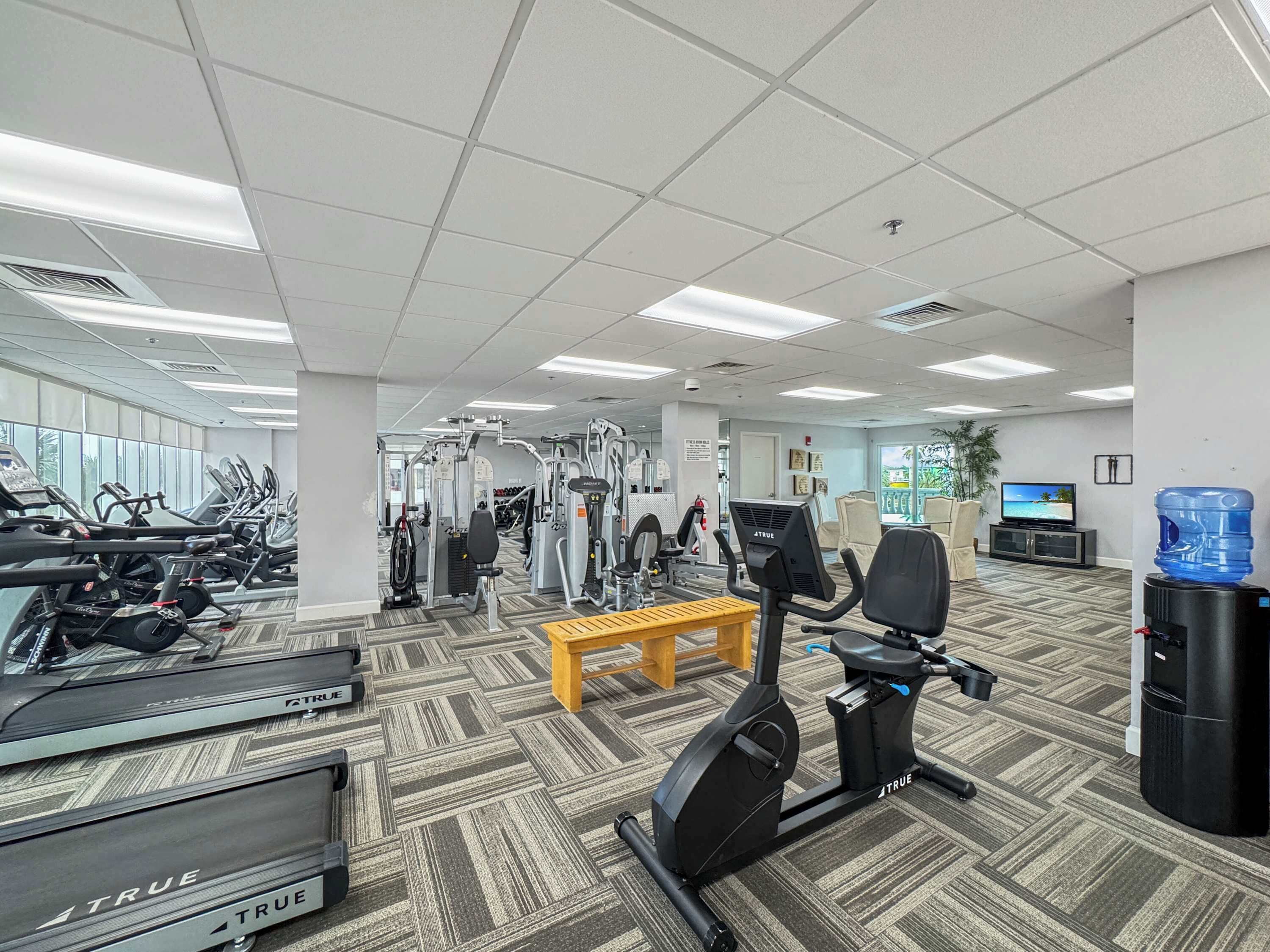 Ein Fitnessstudio mit Laufbändern, Crosstrainern und Gewichten.