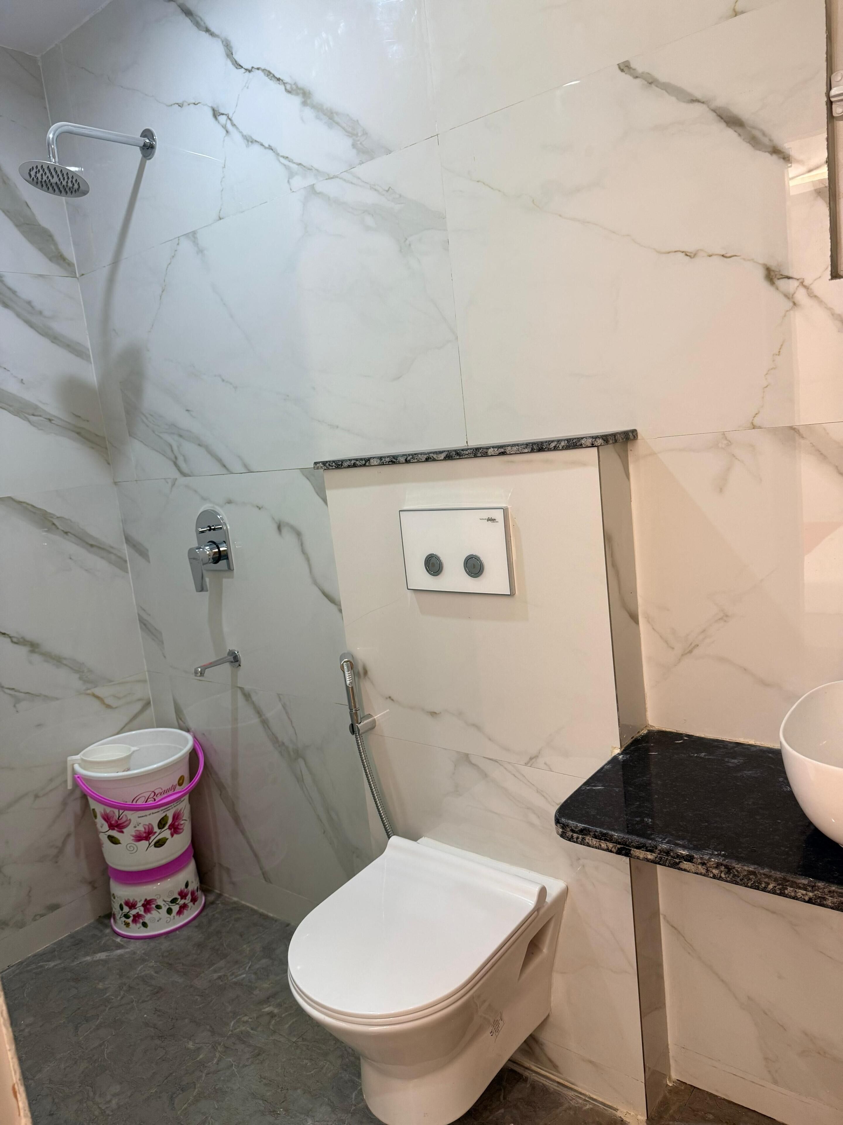 A bathroom with a toilet, shower, and sink.