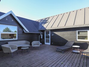 A wooden deck with outdoor furniture, including chairs and a table. - 4 Star Holiday Home in Vaeggerlose (Vaeggerlose)