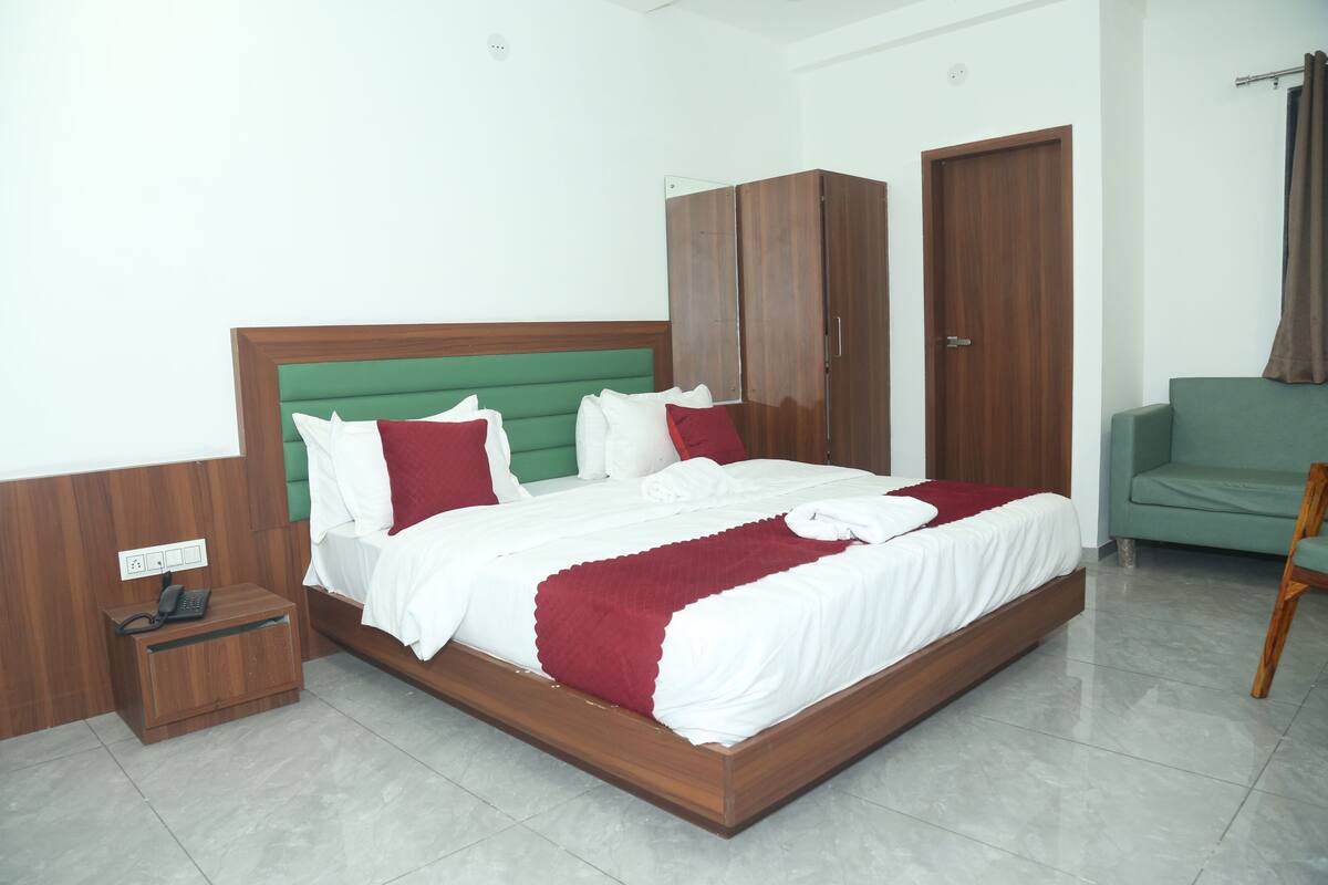 A neatly arranged bedroom with a bed, wardrobe, and a small bedside table.