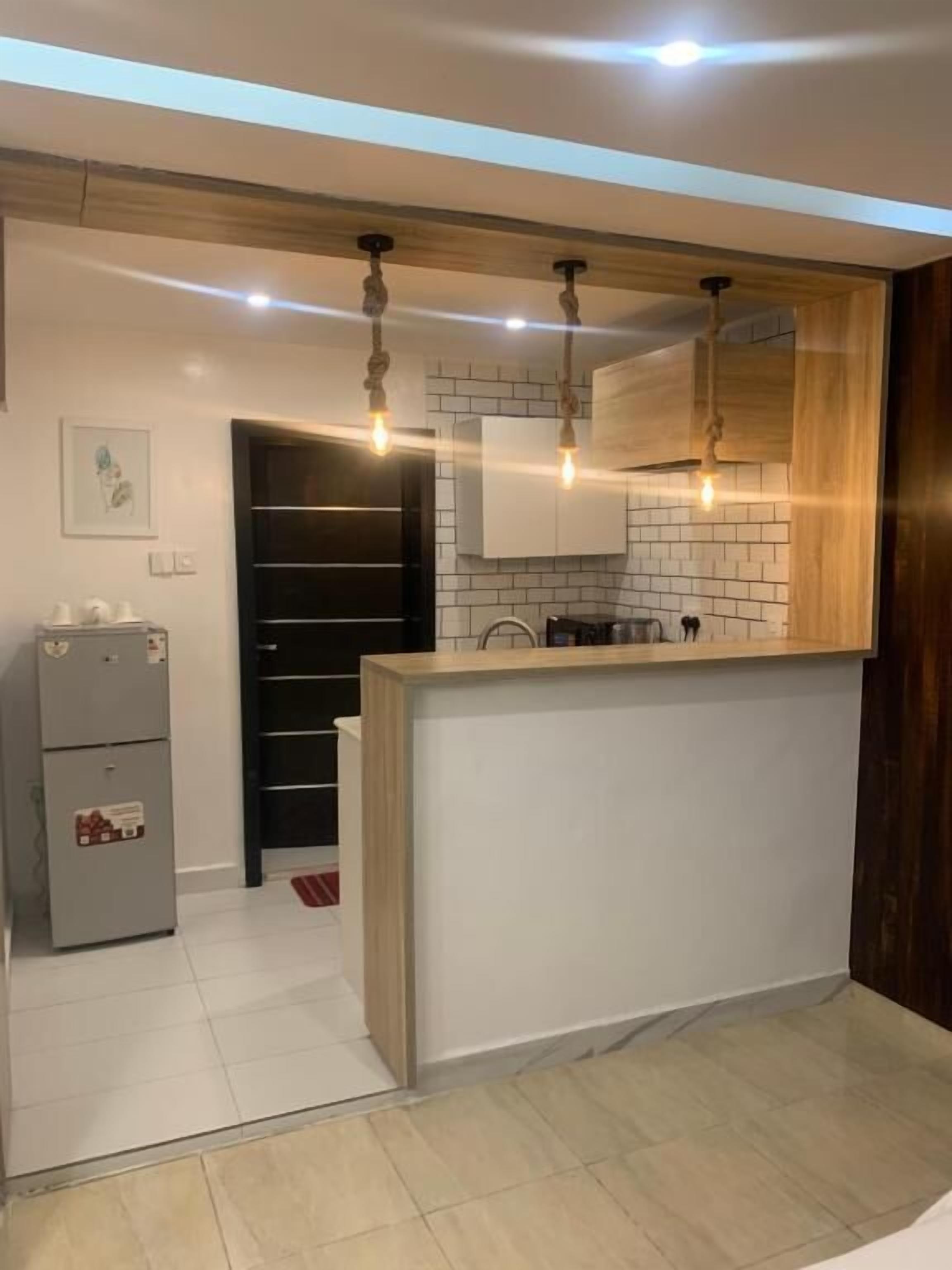 Una cocina moderna con una isla central, iluminación colgante y un horno empotrado.