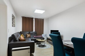 Ein modernes Wohnzimmer mit einer Couch, einem Couchtisch und einem Fernseher.
