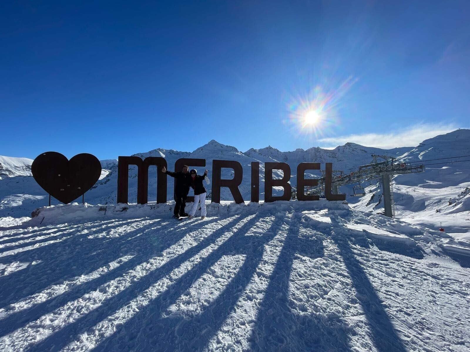 A snowy mountain landscape with a large heart-shaped sign and the word 'MIRIBEL' in the foreground.