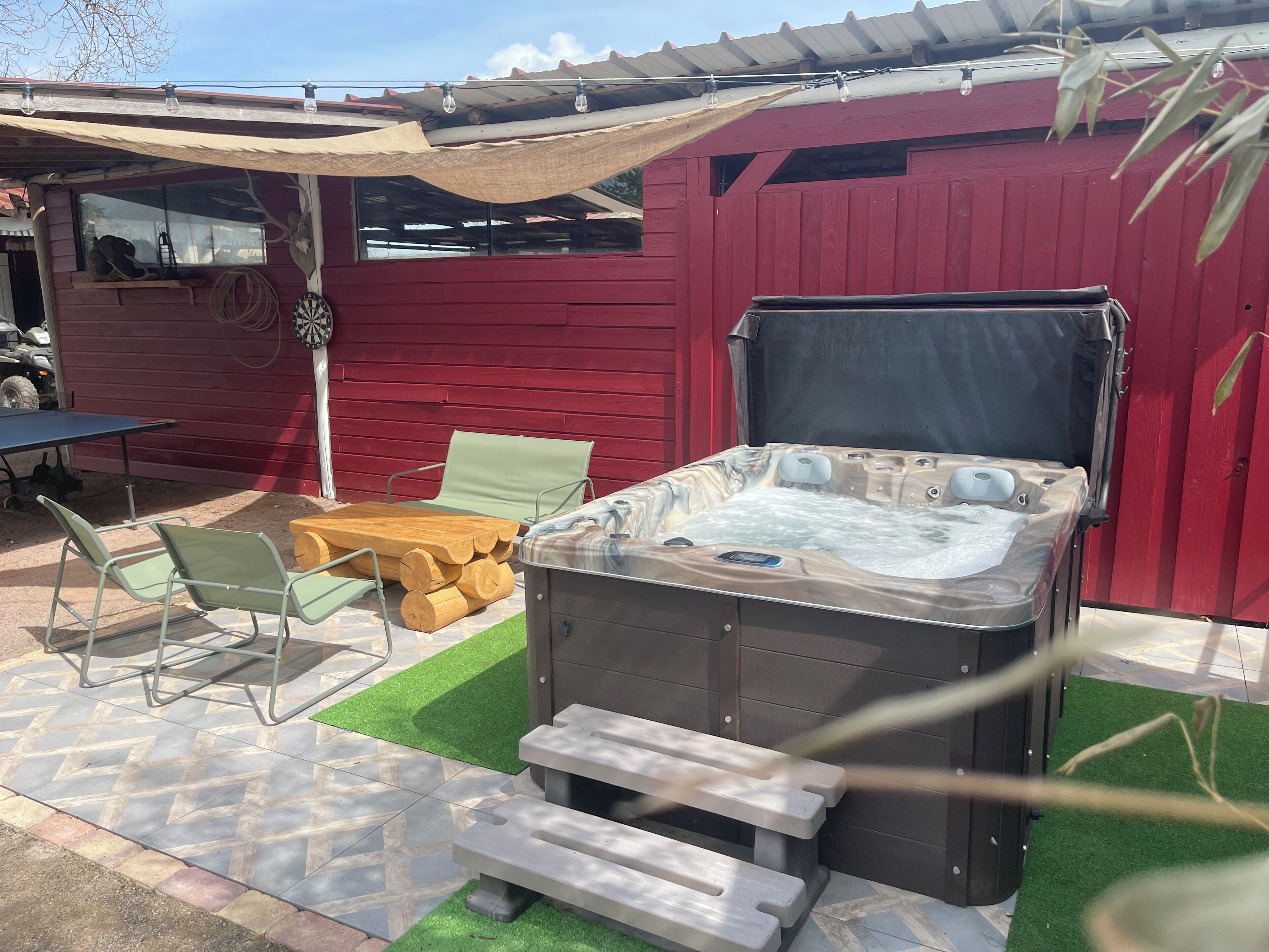 Ein Whirlpool, Sitzgelegenheiten im Freien und eine überdachte Terrasse.