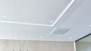 Una recepción con encimera de mármol verde, un logotipo en la parte superior e iluminación empotrada en un techo moderno.