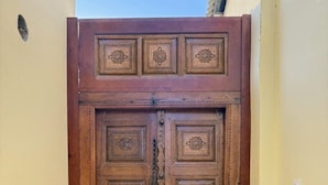 A wooden double door with intricate carvings and a metal handle. - ORIENT HOUSE  (Bukhara)