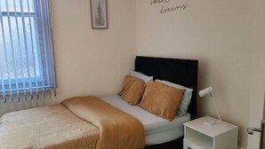 A bed with a headboard, a bedside lamp, and a wall with a text saying 'sweet dreams'. - glamsflat troccadero (Wolverhampton)