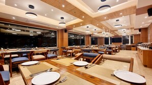 Un restaurante con varias mesas, sillas y una zona de bar.