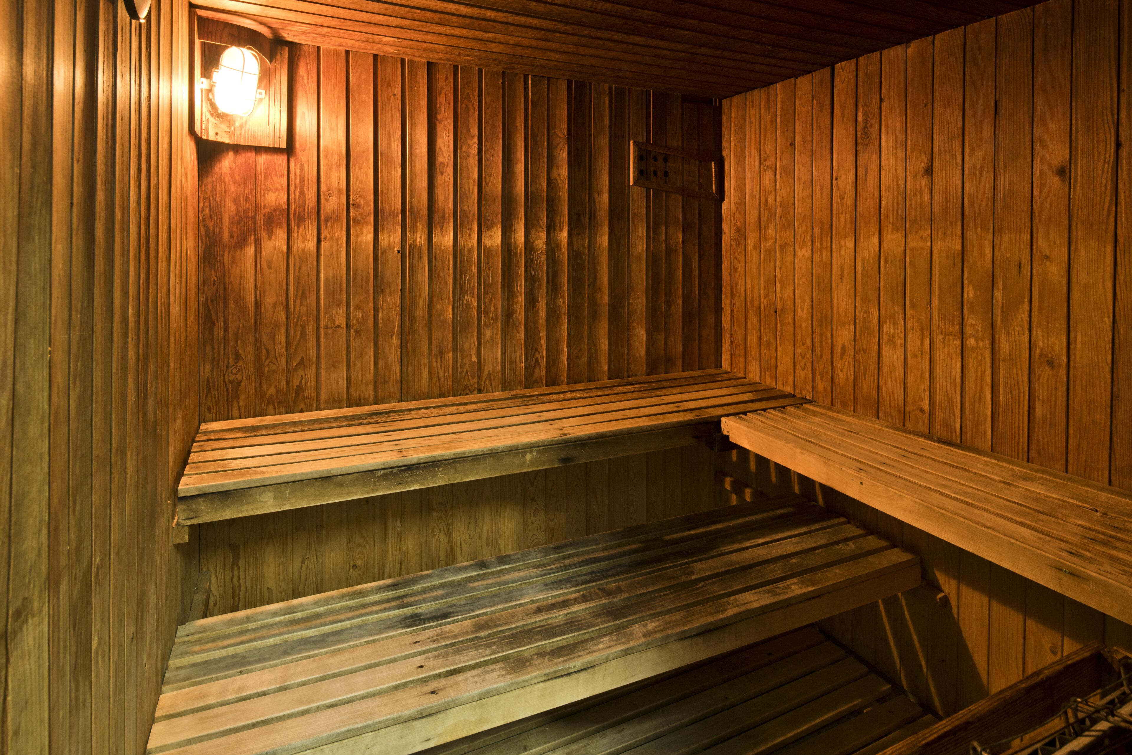 Una sauna con bancos de madera y una lámpara.