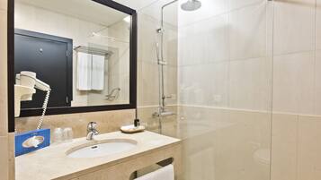A bathroom with a sink, mirror, and shower.