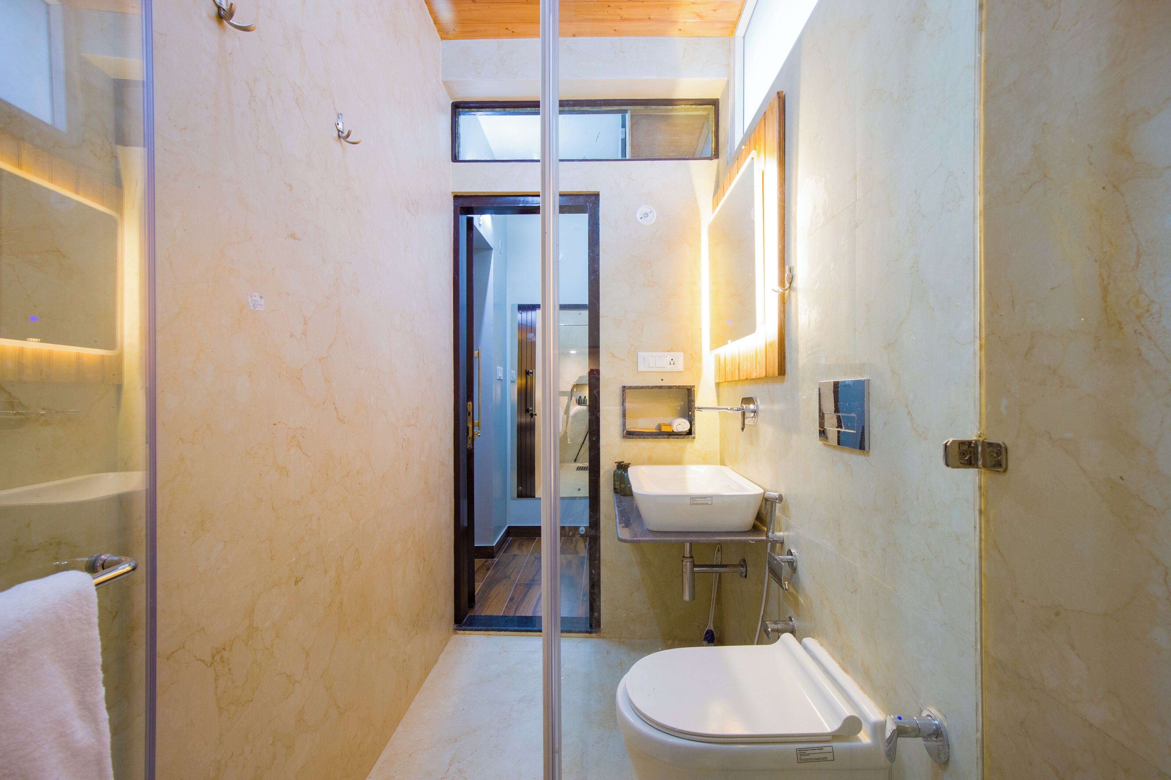 A modern bathroom with a glass shower enclosure, a white sink, and a toilet.