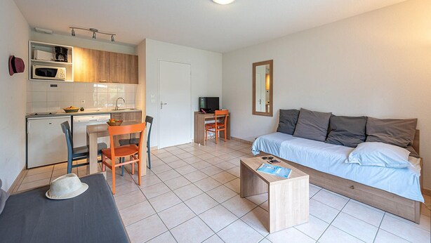 A compact living space with a kitchenette, a dining area, a work desk, a sofa, and a small table. - Duplex Cottage With Pool for 4 (Saumur)