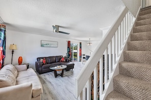 Ein Wohnzimmer mit Sofa, Couchtisch und einer Treppe.