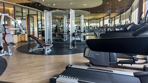 Ett gym med löpband, styrketräningsmaskiner och fria vikter.