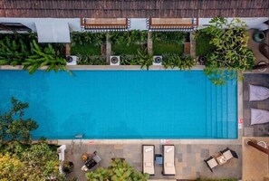 An aerial view of a swimming pool with lounge chairs and greenery around it. - Amã Stays & Trails 70 Vale, Goa (Assagao)