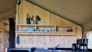 A wooden kitchen with a sink, shelves, and various utensils. - Luxury Glamping Near the Frisian Waters (De Veenhoop)