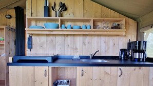 A wooden kitchen with a sink, cabinets, and a countertop. - Luxury Glamping Near the Frisian Waters (De Veenhoop)