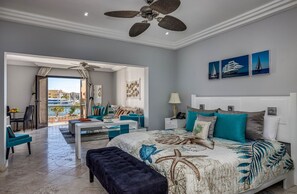 A modern bedroom with a bed, a desk, and a balcony with a view. - Paradise Cove Cap Cana Monthly Rental (La, Altagracia)