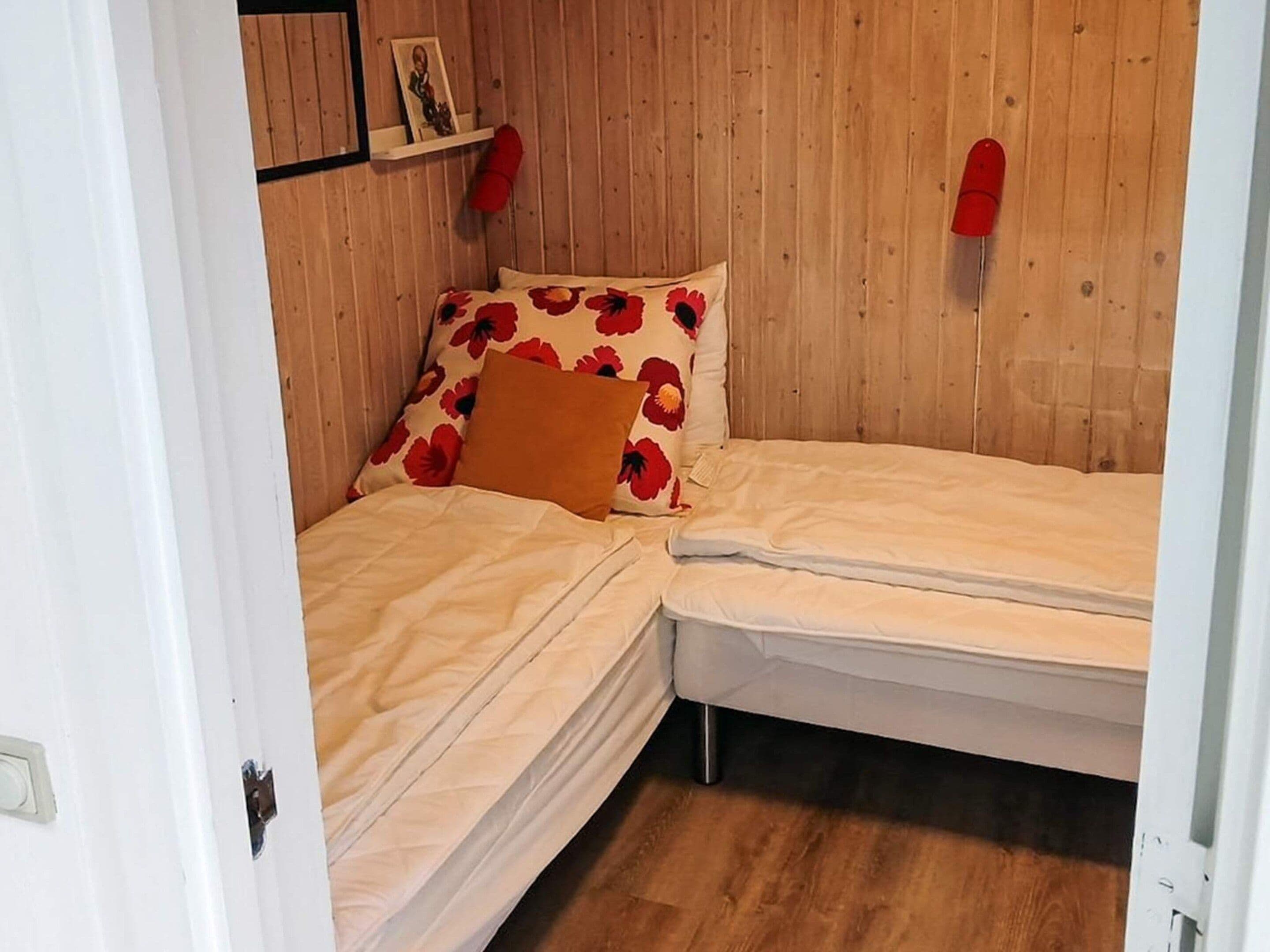 A small, single-bed room with a wooden wall and a white door.