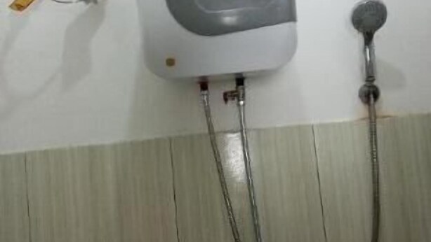 Chuveiro fixado na parede, com painel de controle e chuveiro manual.