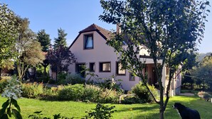 A house with a garden, a tree, and a dog. - Spacious, two-bedroom garden apartment. Free gated parking. (Český Krumlov 1)