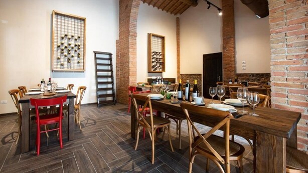 Un comedor con paredes de ladrillo, mesas y sillas de madera.