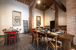 Un espace repas avec des murs en briques, des tables et des chaises en bois.