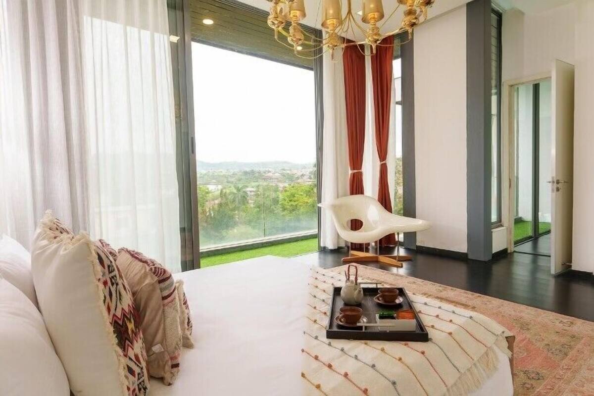 Ein modernes Hotelzimmer mit einem großen Bett, einem Essbereich und Blick auf die Stadt.