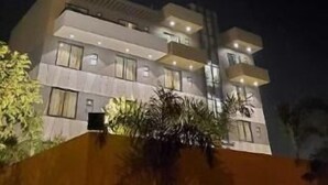 A multi-story building with balconies and windows, surrounded by greenery. - Hotel The Golf (Lucknow)