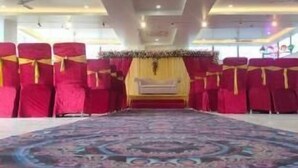 A hotel room with a large carpet, red chairs, and a bed with a yellow headboard. - Hotel The Golf (Lucknow)