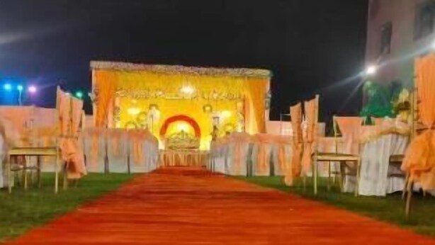 A red carpet leading to a stage with a yellow backdrop and a red arch. - Hotel The Golf (Lucknow)