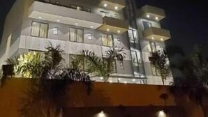 A multi-story building with balconies and windows, surrounded by plants. - Hotel The Golf (Lucknow)