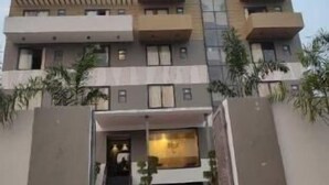 A multi-story building with a modern architectural design, featuring balconies and a central entrance with steps. - Hotel The Golf (Lucknow)