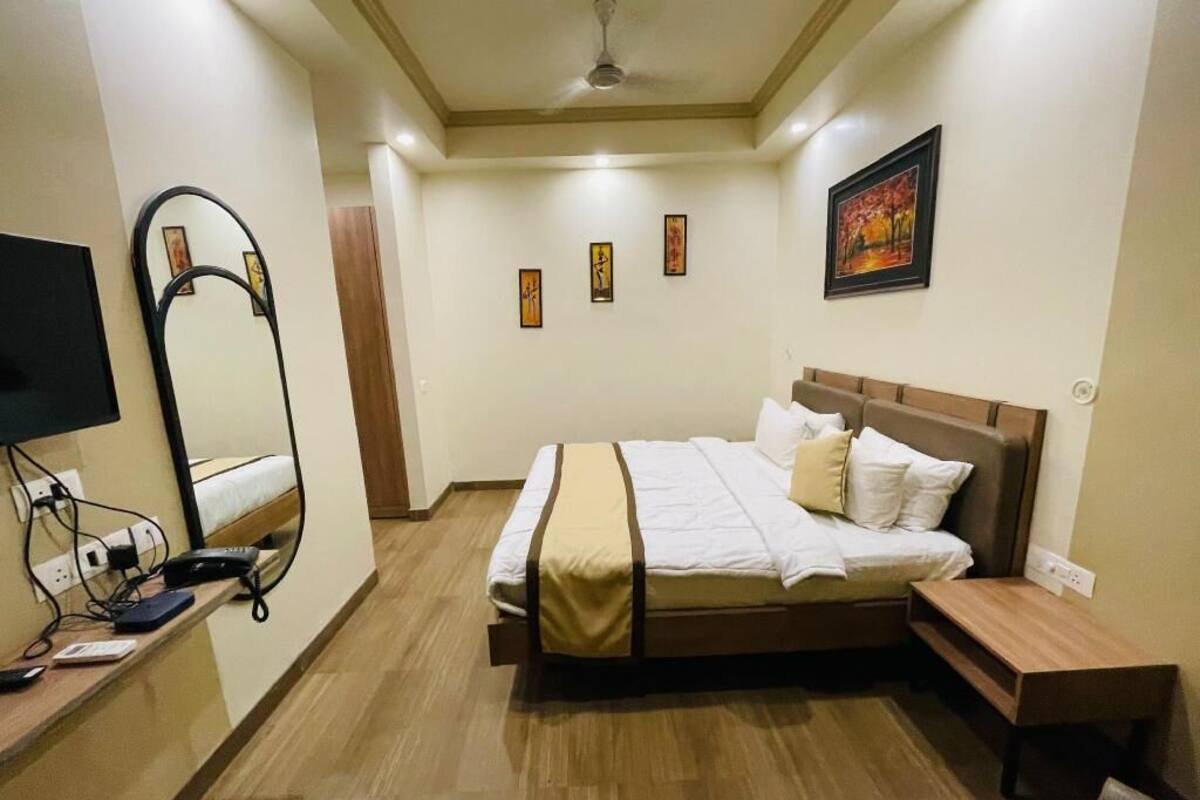 Une chambre à coucher avec un lit, une table de chevet et un téléviseur fixé au mur.