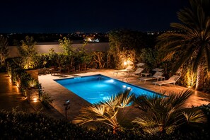 Ein rechteckiger Pool mit Liegestühlen und einem Kiesweg.