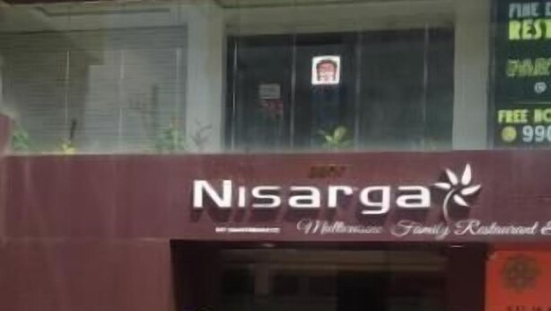 En byggnad med en skylt som visar ordet ”Nisarga” och en trappa som leder till entrén.
