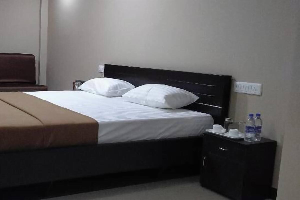 Ein Hotelzimmer mit einem Bett, einem Nachttisch und einem Beistelltisch.