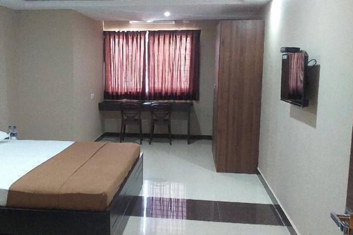 Ein Hotelzimmer mit Bett, Schreibtisch und Stuhl.