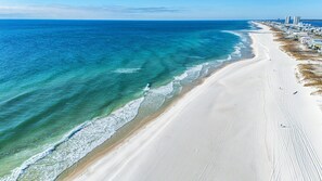 Una playa costera con una amplia orilla arenosa y un océano azul claro.