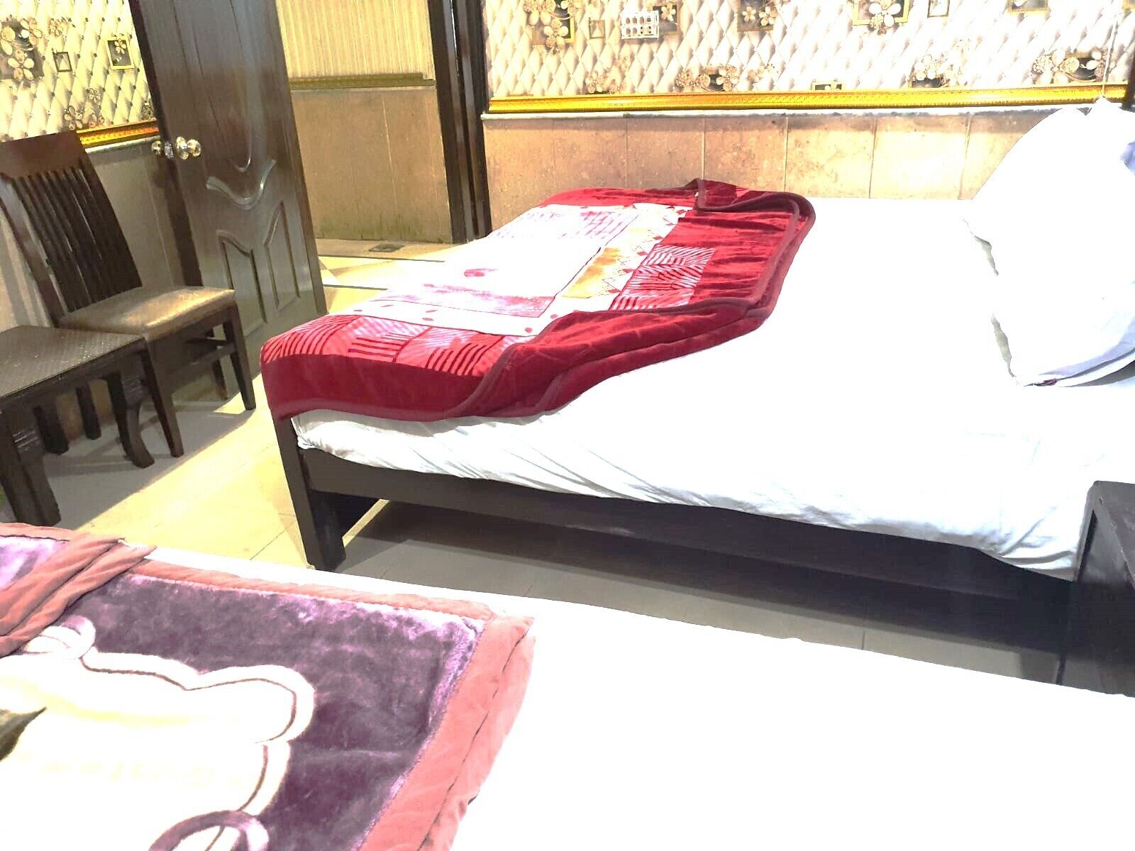 A room with a bed, a chair, and a small table.