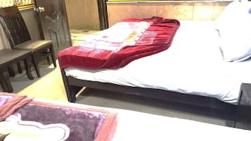 A room with a bed, a chair, and a small table.