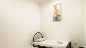 A room with two single beds, a ceiling fan, a wall-mounted light, and a framed artwork. - Rasa Sayang at The Loft Imago (Kota Kinabalu)